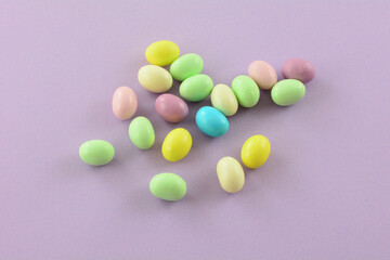 White chocolate covered fruit gummy candy in pastel colors on lavender background