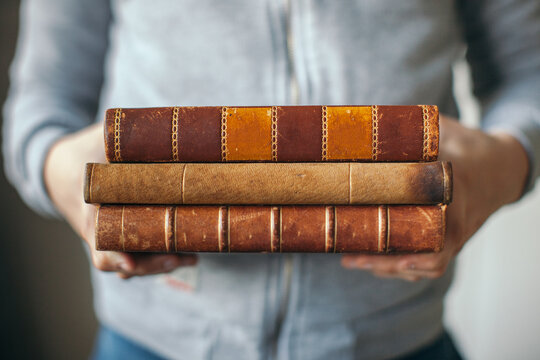Young Boy holding a stack of vintage books