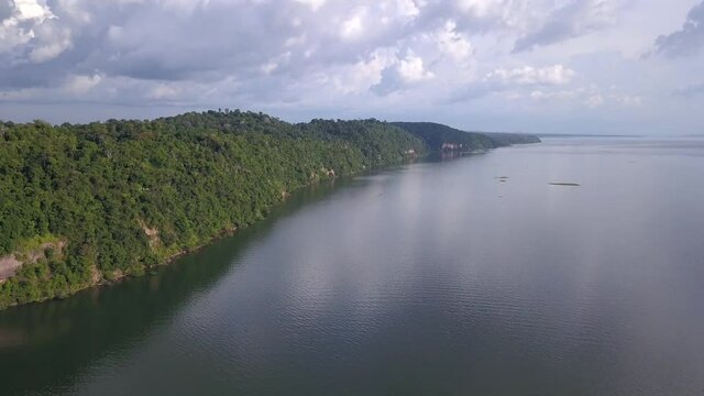 Beautiful drone aerial view of Tapajos river landscape, hills and trees of Amazon rainforest in cloudy summer day. Concept of climate change, global warming, carbon, co2, conservation, ecology.
