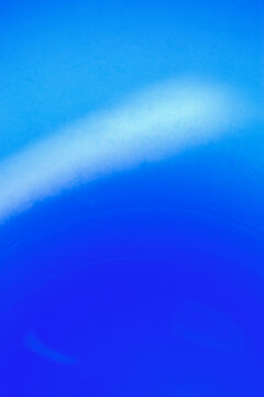 Soft focus of light reflected in the bottom of a handblown blue glass