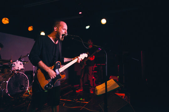 Band frontman singing out loud on stage