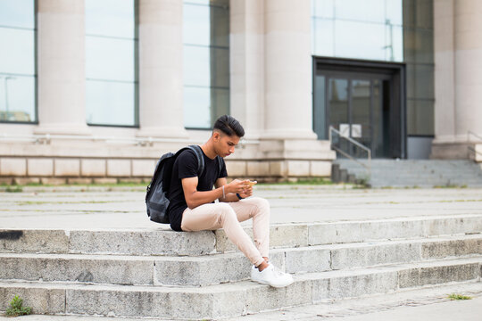 Man using smartphone in a bright location.