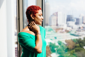 Black Woman looking out window thinking and reflecting at home