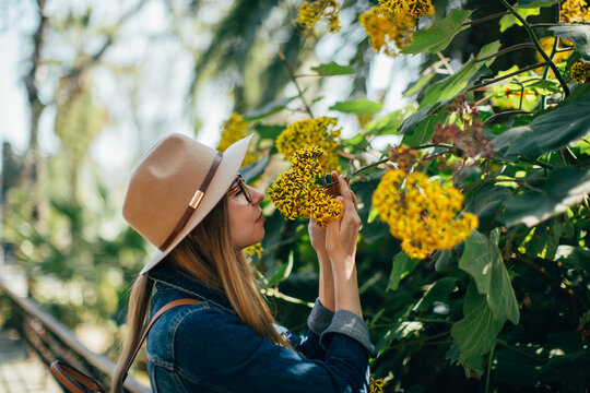 woman sniffing flowers in the park