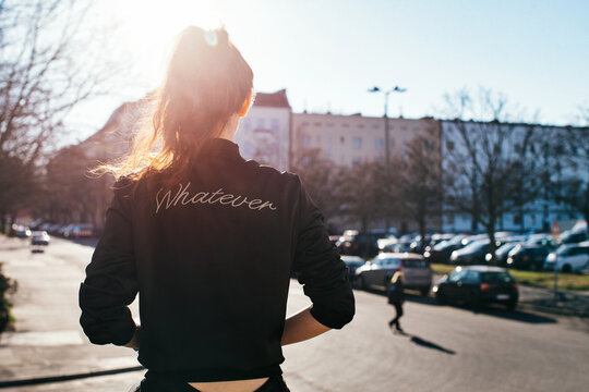 Young Faceless Girl Wearing Bomber Jacket With the Word Whatever on Back