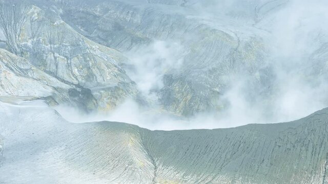 View from above, stunning aerial view of the Tangkuban Perahu volcano with clouds of gases raising from the crater. Tangkuban Perahu is an active volcano, situated 30 km north of the city of Bandung