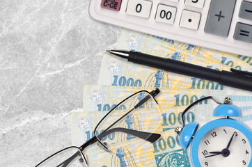1000 Hungarian forint bills and calculator with glasses and pen. Business loan or tax payment...