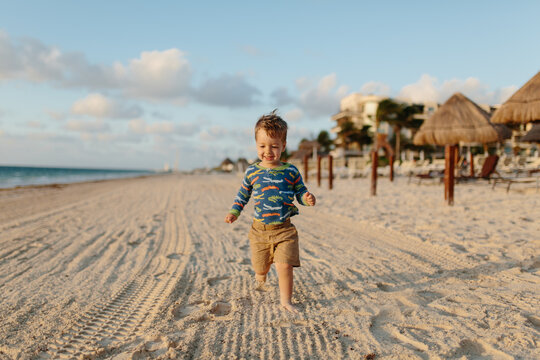 Cute young boy running on a beach