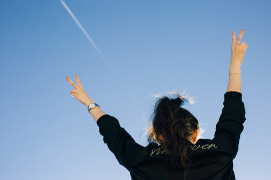 Young Rebel Girl Wearing Bomber Jacket With the Word Whatever and Showing Peace Sign