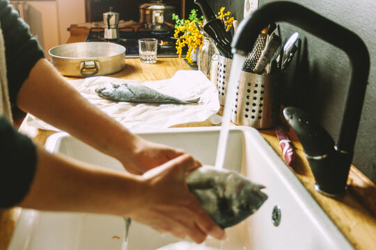 Cooking a fresh gilthead seabream with lemon, garlic and herbs, covered with salt