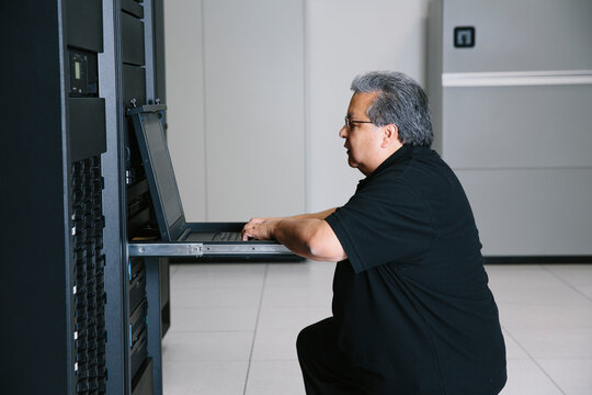 IT programmer working on network on laptop