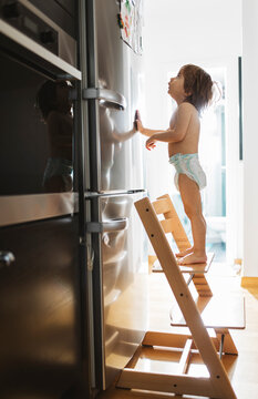2 year old boy in front of a refrigerator