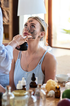 Woman is being applied cleanising facial mask.