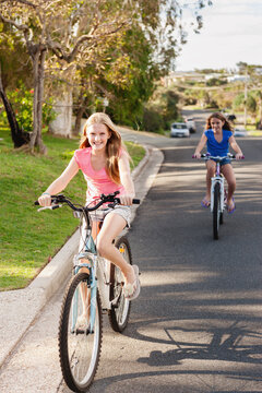 tween girls riding bikes on the street