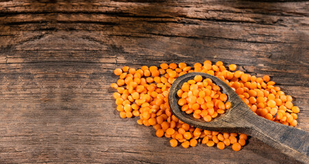 Obraz na płótnie Canvas Lens culinaris - Uncooked red lentils on rustic wooden background