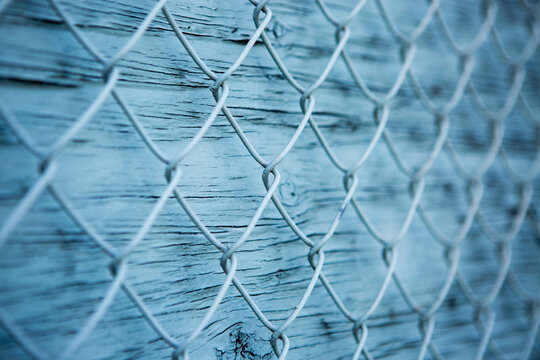 Blue wire mesh fence over blue wooden wall