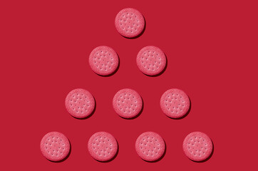 Pattern from pink biscuits on an red background. Abstract background