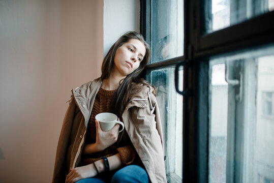 Female leaning head on window sill