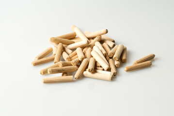 pile of wooden dowels on white table, carpentry connectors, selective focus