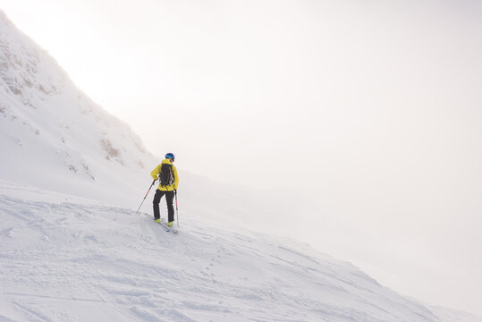 Male skier ski touring to the top of the mountain