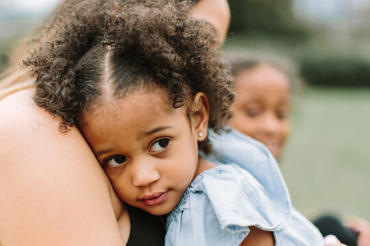 A mother and daughter with curly hair enjoying a beautiful day outdoors