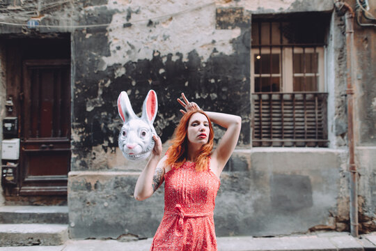 woman holding a bunny mask pretending to have rabbit ears