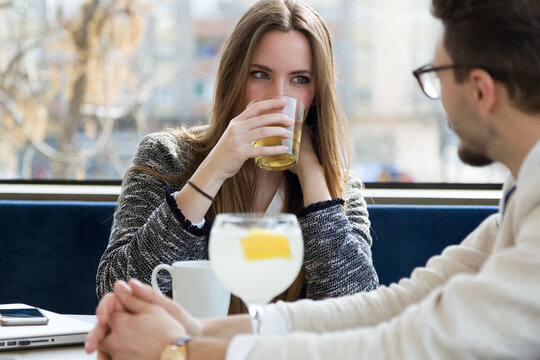 Young business couple drinking something at a coffee shop.