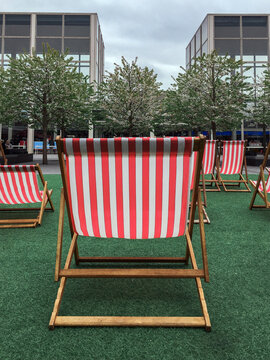 Double red and white deck chair in public area of a city centre