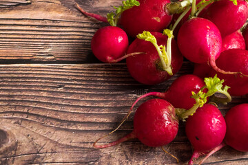 Top view of red ripe radishes on wooden background