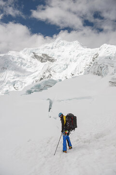 Man exploring snow capped mountain plateau