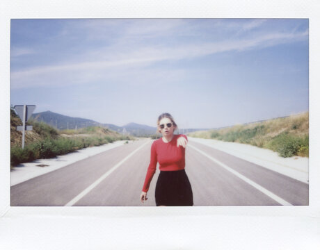 Woman in sunglasses walking towards camera with outstretched arm