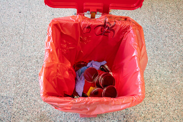 Medical waste bucket. Medical waste, laboratory used petri dishes and gloves and empty vials in the...