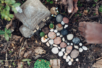 Black girl's hand decorating a fairy house