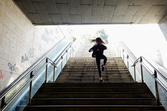 Young woman dancing on the metro stairways