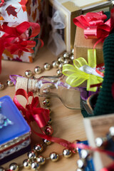 Some different gifts with red ribbons on a wooden table 