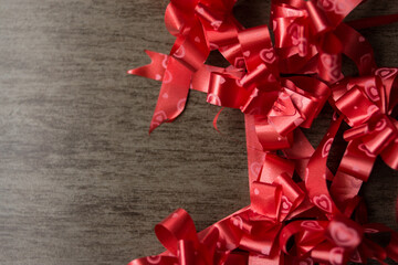 Some red ribbons on a wooden table for decoration 
