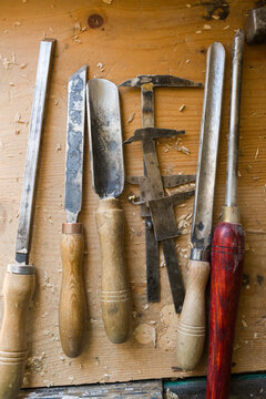 Handicraft tools aligned on wooden workbench