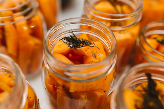 Carrots and dill being preserved in mason jars