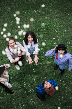 Group of friends throwing popcorn upwards