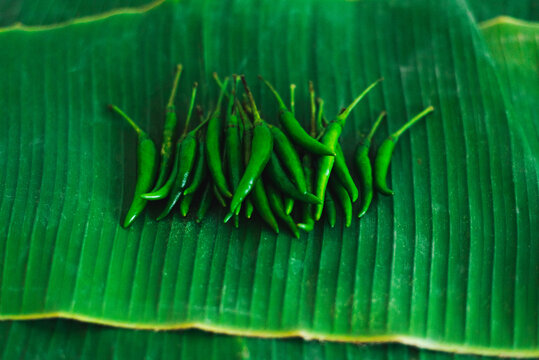 young green chilli on banana leaf
