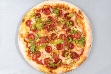 Overhead view of healthy sized pepperoni and green pepper pizza with thick crust to complete a delicious meal to eat