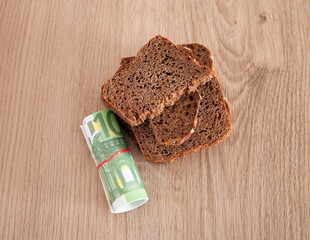 A roll of euro bills and black bread