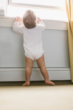 Young Toddler Reaching up to look out window