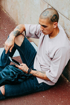 Young tattooed checking his phone