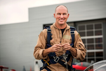 Fighter pilot looking at camera smiling while tying string together getting ready for a flight