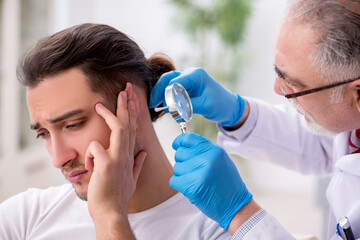 Young man visiting experienced doctor dermatologist