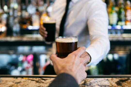 Restaurant: Customer Reaches To Take Beer From Bartender