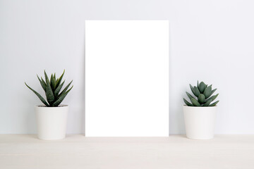 Blank paper sheet copy space with mockup and plants in potted on wooden table, poster and invitation with empty on desk, card decoration your design or branding, simplicity and minimal, nobody.