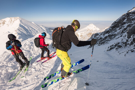 Three skiers on snow-capped mountain peak