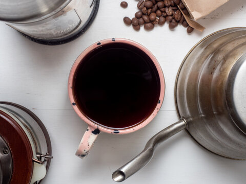 Millennial pink coffee mug with beans, pot, grinder, and french press